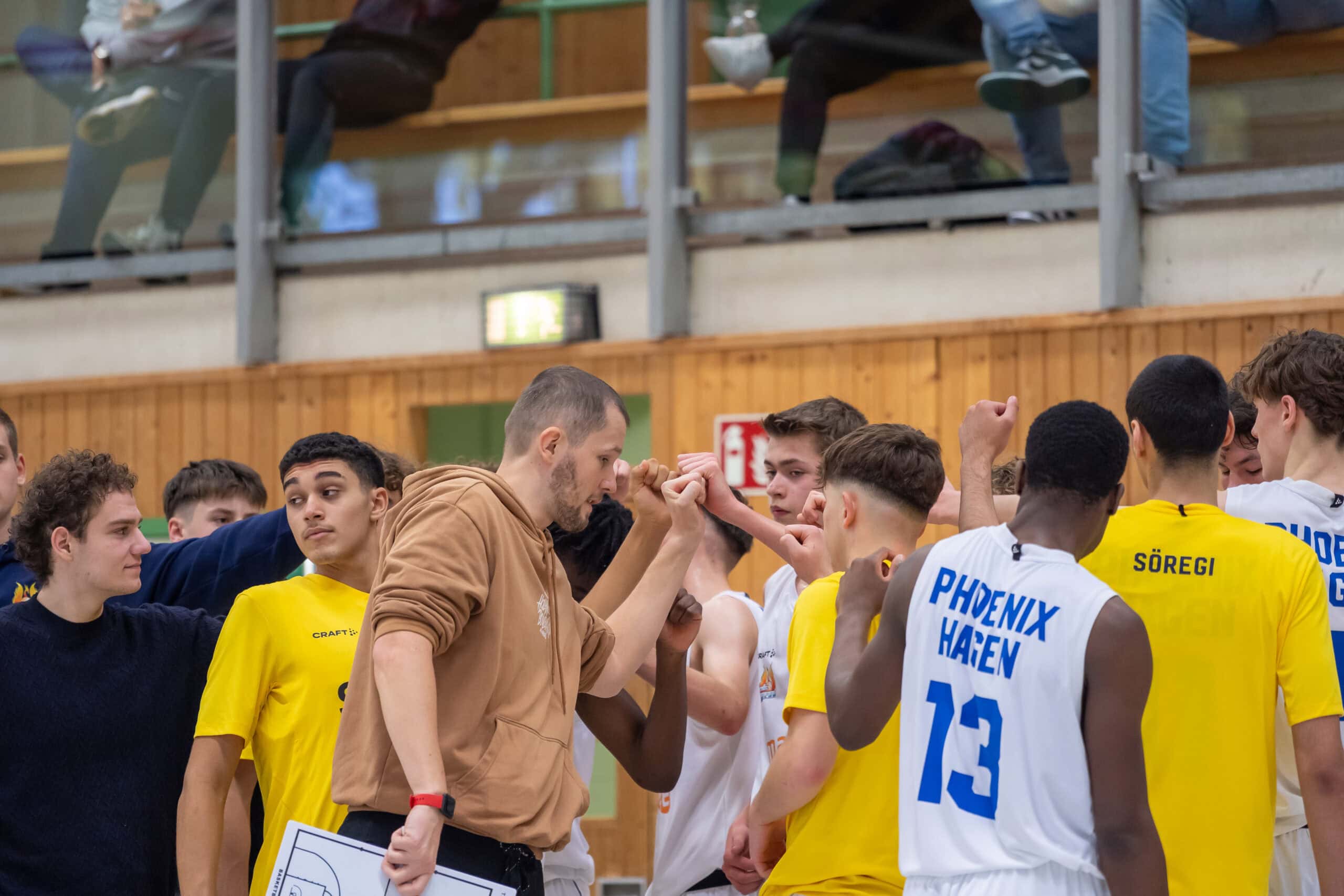 Ein Basketballteam in gelben Trikots vereint sich motiviert für eine Teambesprechung.