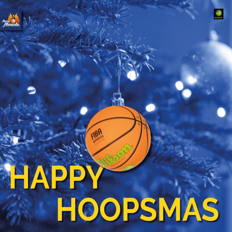 Ein Basketball-Ornament hängt an einem beleuchteten, blauen Weihnachtsbaum.