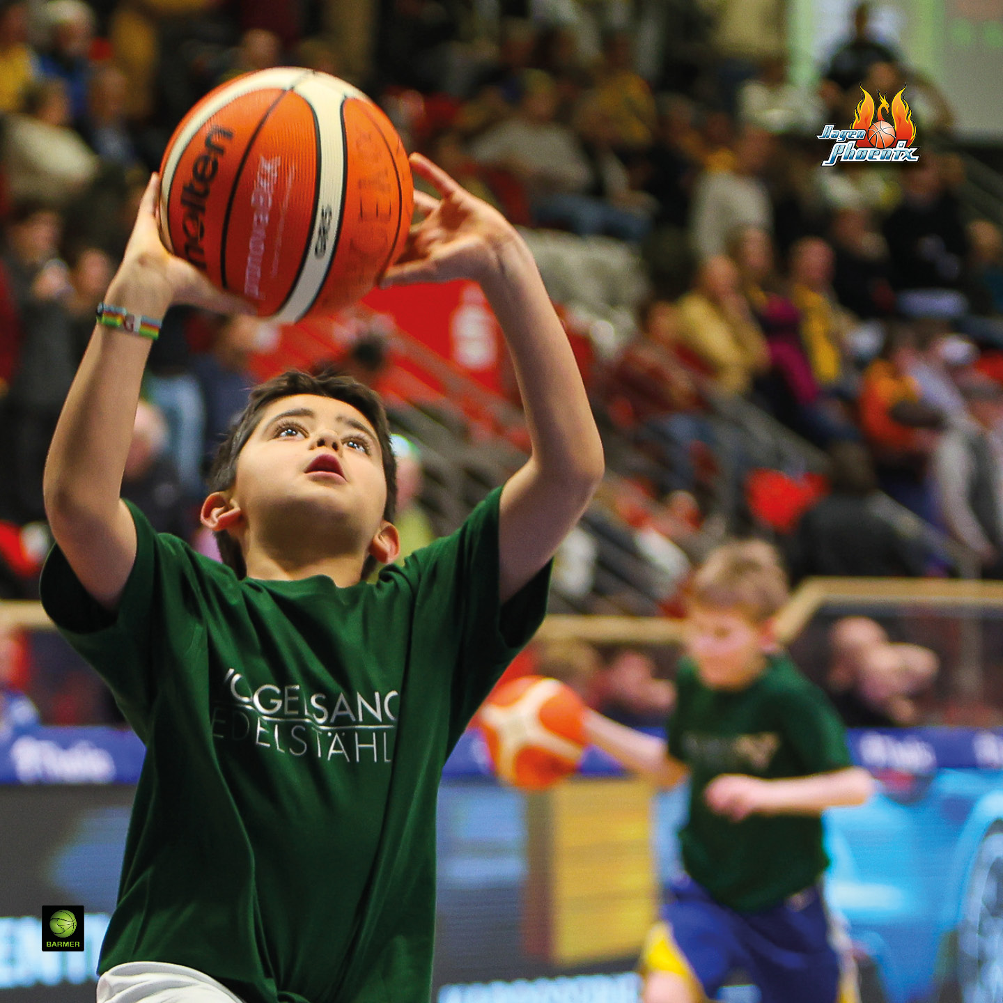 Kind beim Basketballspiel in grünem Trikot, konzentrierter Gesichtsausdruck, Halle im Hintergrund.